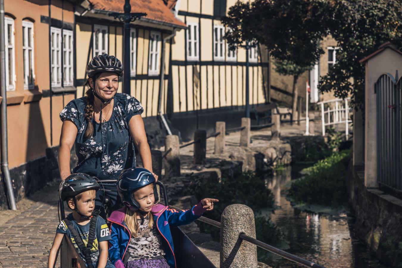 Familie cykler ved bybækken i Bogense