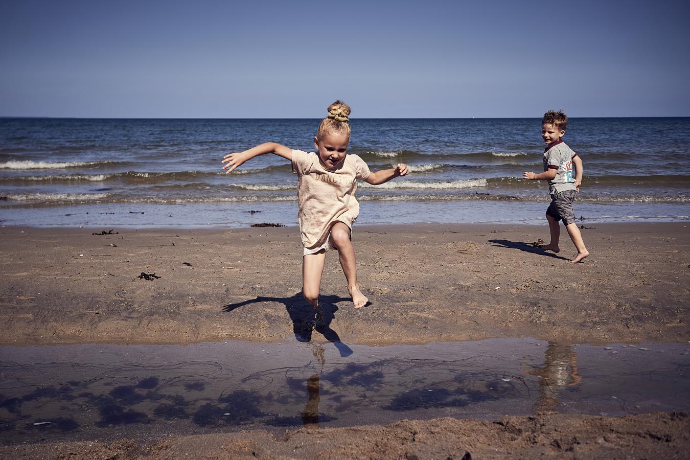 2 børn leger på stranden i sommer på Flyvesandet Strand