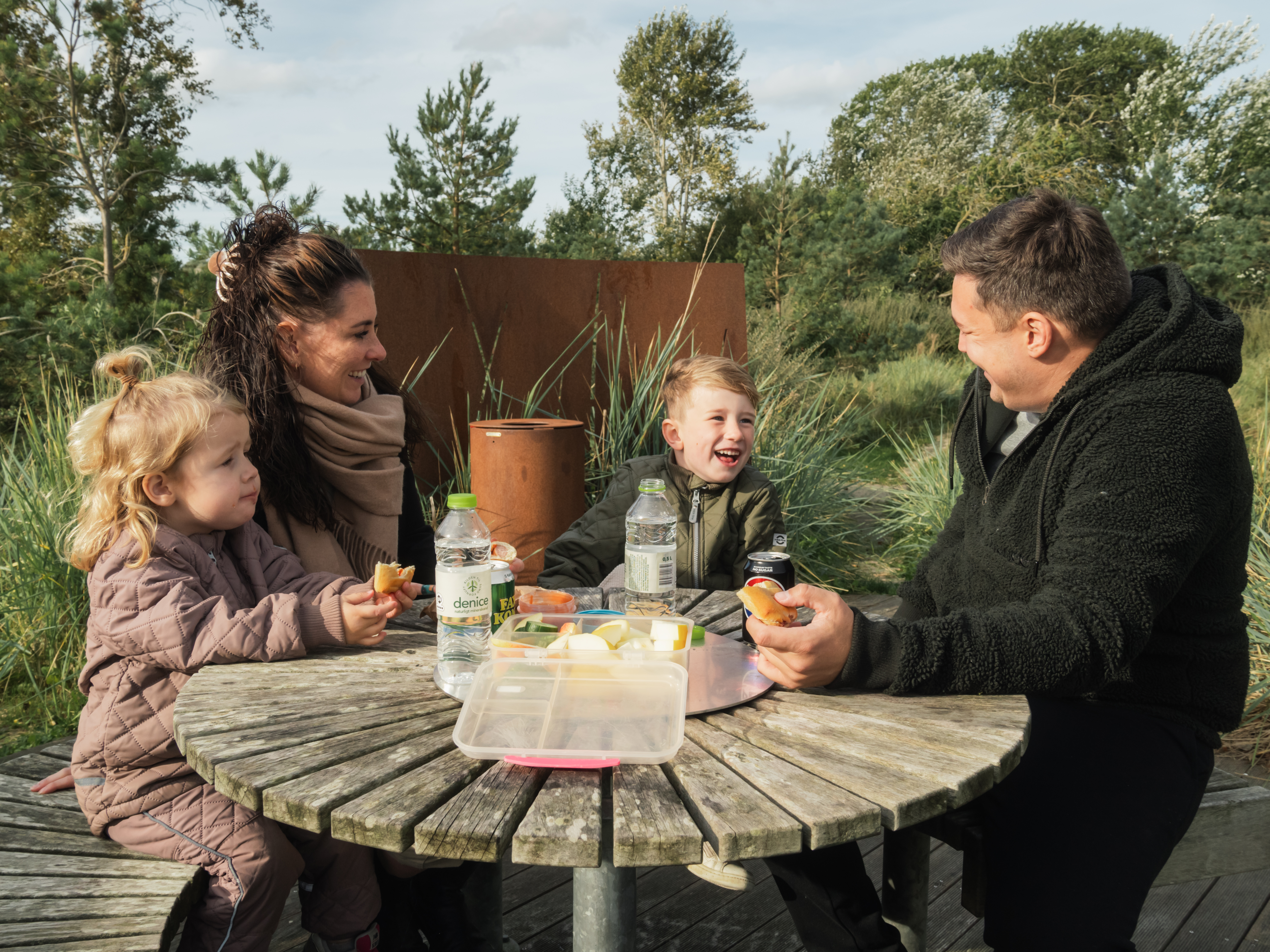 Familie spiser picnic på Hasmark Strandoase i efteråret
