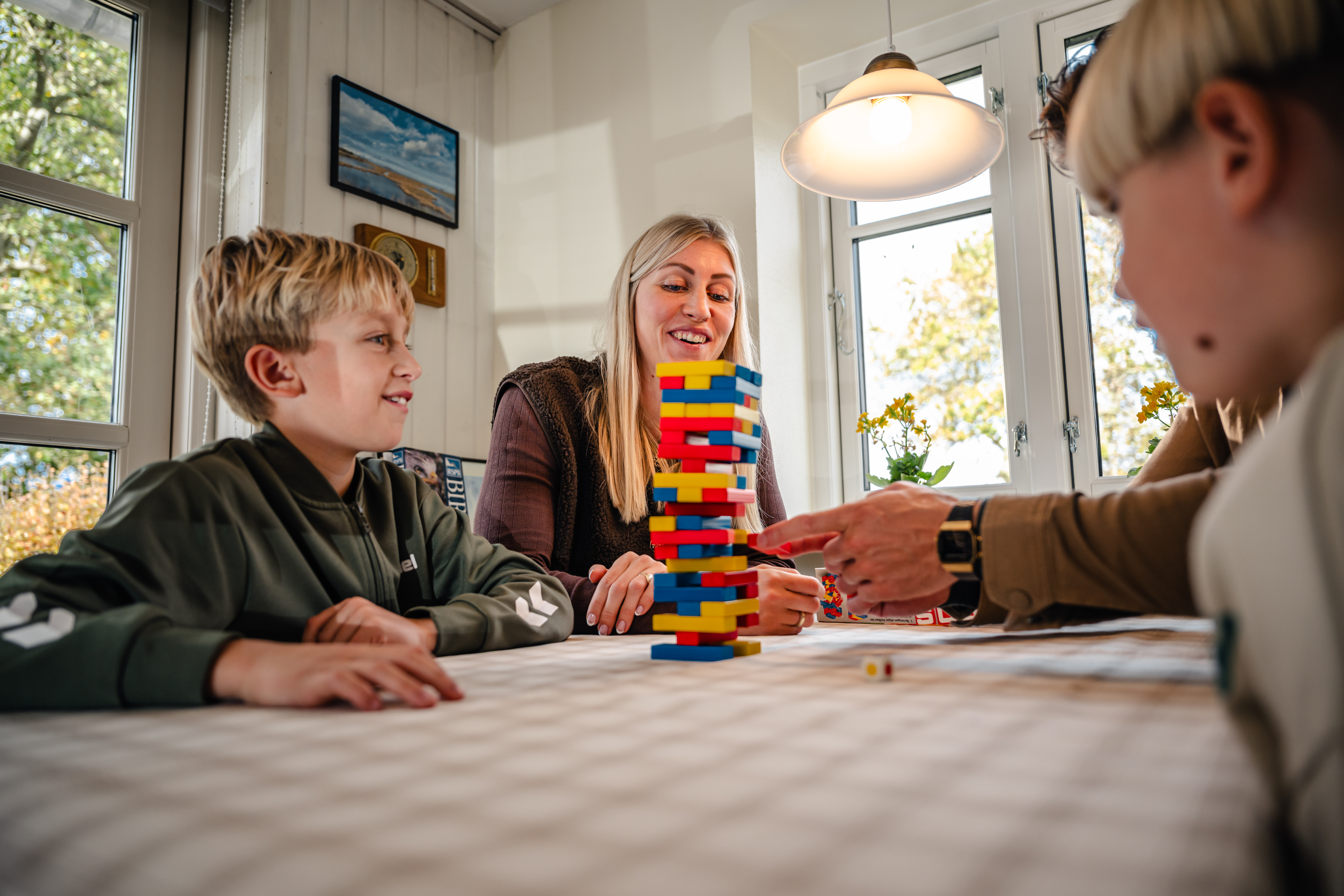 Familie leger sammen i sommerhus i efterårsferien