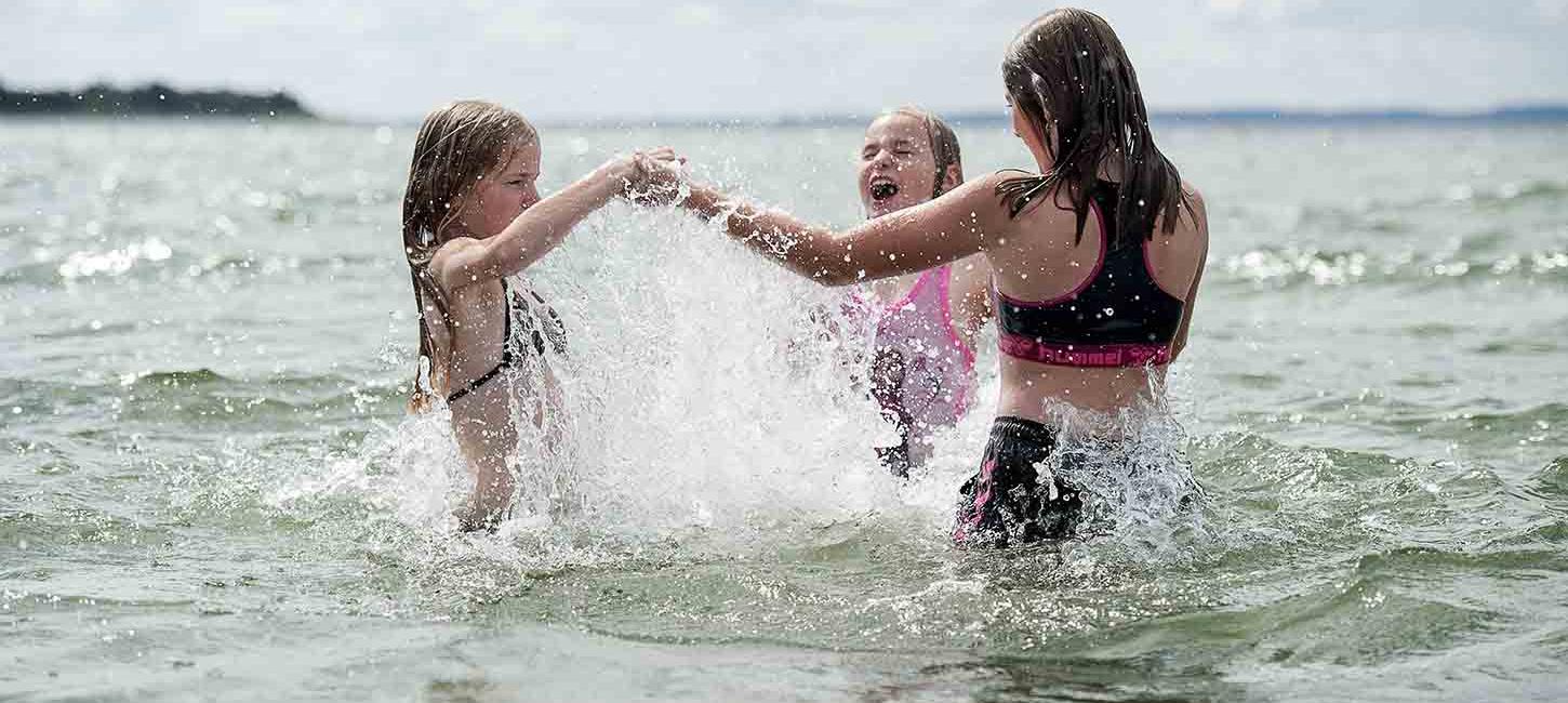 Tre piger bader ved stranden på Nordfyn