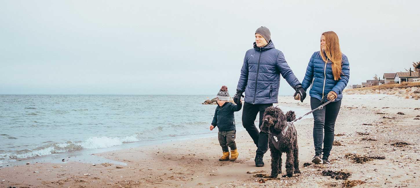 Mor, far, barn og hund går tur på Fuglsang Strand i vintertid