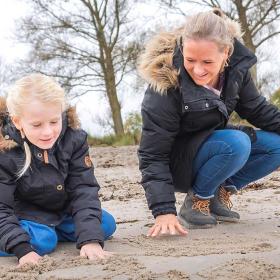 Mor og datter leger på Hasmark Strand i efterårs- og vintertiden
