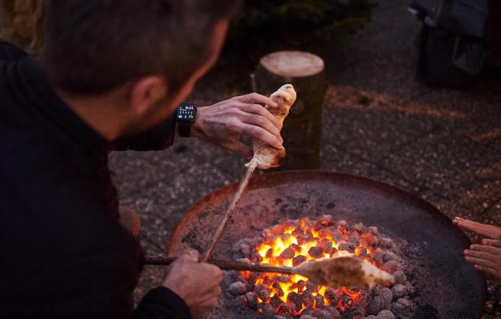Far bager snobrød over ild på Otterup Julemarked